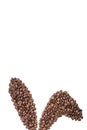 Easter holiday background with bunny ears made of freshly roasted coffee beans on a white background. Creative easter concept.