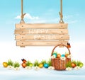 Easter Holiday Background with colofrul eggs in green grass and wooden sign.