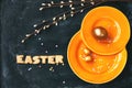 Easter holiday background, orange plate, golden eggs