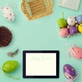 Easter holiday background with retro filter effect. Easter eggs decorations and tablet. View from above