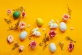 Easter holiday concept with cute handmade colorful eggs, egg tray, bunny and flowers on yellow background. Flat lay concept, top Royalty Free Stock Photo