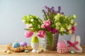 Easter holiday concept with Easter eggs and beautiful tulip flowers bouquet on wooden table Royalty Free Stock Photo