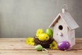 Easter holiday concept with eggs decorations and bird house