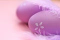 Easter holiday.Easter lilac eggs close-up and purple feathers on a pink background.Festive easter background in pastel Royalty Free Stock Photo