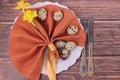 Easter holiday table setting with cutlery on barn boards. Narcissus, quail eggs,eating utensils, napkin and white plate Royalty Free Stock Photo