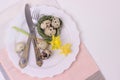 Easter holiday table setting with cutlery on white background.Narcissus, quail eggs, eating utensils on white plate Royalty Free Stock Photo