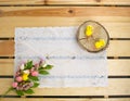 Easter holiday. White lace napkin, chickens toys on slice and bouquet of flowers with eggs on wooden background. Vintage backgroun Royalty Free Stock Photo