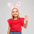 Happy girl wearing easter bunny ears waving hand Royalty Free Stock Photo