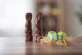 Easter eggs in straw nest and chocolate bunnies Royalty Free Stock Photo
