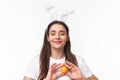 Easter, holidays and spring concept. Close-up portrait of dreamy charming young woman in rabbit ears, daydreaming close Royalty Free Stock Photo