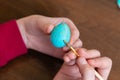 Easter, holidays, tradition and people concept - close up of woman hands coloring easter Quail eggs with colors and brush