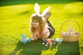 Easter kid in park. Easter kids boy in bunny ears paint easter eggs outdoor. Cute child in rabbit costume with bunny Royalty Free Stock Photo