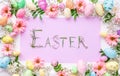 Easter letters made of grass in a frame of colorful eggs and flowers. Easter background, template for design Royalty Free Stock Photo