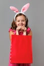 Easter. A little girl in a pink polka dot dress holds a shopping bag in her hands with space for text. Royalty Free Stock Photo