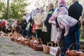 At Easter many people standing in a row with baskets and candles