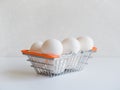 Easter minimalistic concept. White chicken eggs in small metal food basket on white background