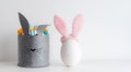 Easter minimalistic decor in the interior. A gray felt basket in the shape of a hare and a large ceramic egg with ears