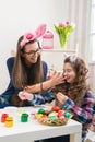 Easter - Mother and daughter paint eggs, bunny ears on them