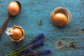 Easter orange eggs on a blue wooden old background. Egg in a spoon and flowers Royalty Free Stock Photo