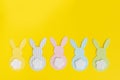 Easter paper bunnys isolated on yellow background. Concept: children`s crafts for Easter. Top view