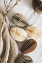 Easter paper eggs decorations and branches on linen tablecloth. Royalty Free Stock Photo