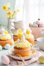 Easter pastry lemon cupcakes with yellow buttercream frosting decorated with sprinkles and chocolate eggs. Festive table setting Royalty Free Stock Photo