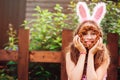 Easter portrait of happy child girl in funny bunny ears playing egg hunt outdoor Royalty Free Stock Photo