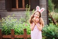 Easter portrait of happy child girl in funny bunny ears playing egg hunt outdoor Royalty Free Stock Photo