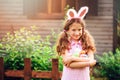 Easter portrait of happy child girl in funny bunny ears playing egg hunt outdoor Royalty Free Stock Photo