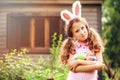 Easter portrait of happy child girl in funny bunny ears playing egg hunt outdoor Royalty Free Stock Photo