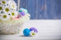 Easter present basket with white flowers and colored eggs on wooden background spring inspiration Royalty Free Stock Photo