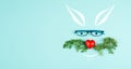 Easter rabbit face with a heart shaped nose, whiskers from carrot leaves and eyeglasse, holiday greeting card, spring