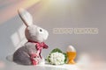 Easter rabbit toy and a cheerful egg in a nest on a white gray background Royalty Free Stock Photo
