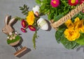 Easter rebbit and Easter eggs with spring flowers in a wicker basket.