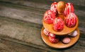 Easter red eggs with folk white pattern lay around stand for eggs which stand on rustic wood background. Top view. Ukrainian tradi