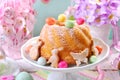 Easter ring cake with candy eggs and cookies on spring table