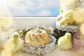 Easter ring cake and seasonal decors on windowsill in sunny day