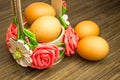 Easter russian still life. Eggs in a flower basket, sweets, rolls, prepared for rest on a wooden background Royalty Free Stock Photo