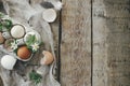 Easter rustic flat lay. Natural easter eggs, blooming spring flowers, feathers, burlap on rural wooden table. Happy Easter! Simple Royalty Free Stock Photo