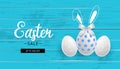 Easter sale. Blue wooden background. Eggs and hand drawn bunny ears Royalty Free Stock Photo