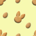 Easter seamless pattern of cookies shaped of bunny and eggs on yellow background. Royalty Free Stock Photo