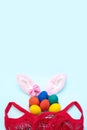 Easter shopping concept. Hand painted Easter eggs, pink bunny ears and a red shopping bag Royalty Free Stock Photo