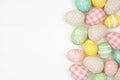 Easter side border with farmhouse style cloth and pastel colored eggs over a white wood background