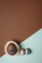 Easter, silver, brown, blue eggs on brown - blue background. Decorated with feathers