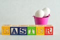 Easter spelled with alphabet blocks and a bucket of eggs Royalty Free Stock Photo