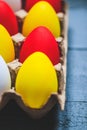 Easter spring composition, box with painted colorful eggs. Close up portrait on blue wooden background. Selective focus Royalty Free Stock Photo