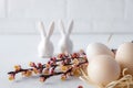 Easter spring decorative composition  with easter eggs pink cherry branch and ceramic bunny.  On a white background Royalty Free Stock Photo