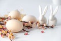 Easter spring decorative composition  with easter eggs pink cherry branch and ceramic bunny.  On a white background Royalty Free Stock Photo