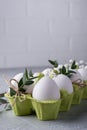 Easter spring decorative composition with easter white chicken raw eggs in carton box Decorated with eucalyptus leaves