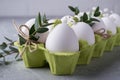 Easter spring decorative composition with easter white chicken raw eggs in green carton box Decorated with eucalyptus